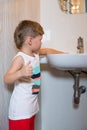 Little boy wets his hands in the washbasin Royalty Free Stock Photo