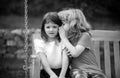 Little boy whispers to lovely girl in ear. Portrait of brother and sister in summer park outdoors. Little boy and girl Royalty Free Stock Photo