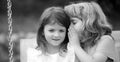 Little boy whispers to lovely girl in ear. Two children outdoors. Portrait of adorable brother and sister smile and Royalty Free Stock Photo