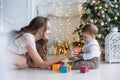 Mom with little son playing with colored blocks near the Christmas tree Royalty Free Stock Photo