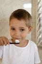 Little boy in white t-shirt brushing his teeth.Milk teeth are replaced by molars Royalty Free Stock Photo