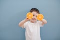 Little boy in white t-shirt holds two orange slices Royalty Free Stock Photo