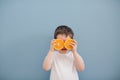 Little boy in white t-shirt holds two orange slices Royalty Free Stock Photo