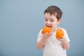 Little boy in white t-shirt holds two orange slices Royalty Free Stock Photo