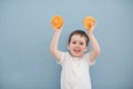 Little boy in white t-shirt holds two orange slices Royalty Free Stock Photo