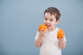 Little boy in white t-shirt holds two orange slices Royalty Free Stock Photo