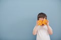 Little boy in white t-shirt holds two orange slices Royalty Free Stock Photo