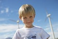 Little Boy With Wind Turbines In The Background Royalty Free Stock Photo