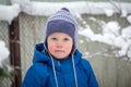 A little boy in a winter hat and jacket while walking on a cold winter snowy day Royalty Free Stock Photo