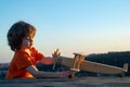 Little boy with wooden plane. Child boy is playing and dreaming of becoming a pilot. Child dreams and imagination