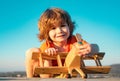 Little boy with wooden plane, boy wants to become pilot and astronaut. Happy child play with toy airplane. Kids pilot Royalty Free Stock Photo