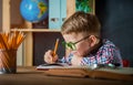 Little boy write on blank paper on desk near the window. Back to school. Educate at home and doing homework. Pupil Royalty Free Stock Photo