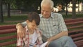 Little boy writes in his notebook what his grandpa says