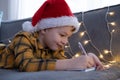little boy writing letter to santa for new year and christmas