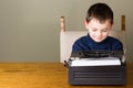 Little boy writing on an old typewriter Royalty Free Stock Photo