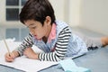 Little boy writing white paper on the floor Royalty Free Stock Photo