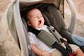 a little boy yawns strapped in a stroller.