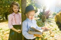 Little boy 6,7 years old with hat, glasses, reading book and girl 7,8 years old Royalty Free Stock Photo