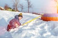 Little boy 3-5 years old, in winter in nature, happy smiling, playing with snow and snow drifts with tubing. Emotions of Royalty Free Stock Photo