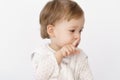 Little boy of 2 years in a sleeping bag shows a gesture quietly holding a finger to his lips on the bed. A smiling Royalty Free Stock Photo