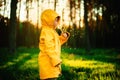 Little boy in a yellow jacket at sunset in the forest blowing a dandelion. Nature care concept.  Take care of the environment. Act Royalty Free Stock Photo