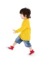 Little boy in yellow shirt walks isolated