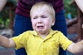 Little boy in a yellow T-shirt is badly upset and crying. Tears on her cheek Royalty Free Stock Photo