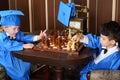 Little boys in blue suits play chess Royalty Free Stock Photo