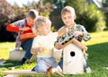 Little boys brothers building birdhouse outdoors