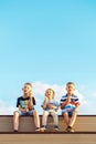 Little boy and elder brothers eat ice cream sit on bench watching movie Royalty Free Stock Photo
