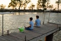 Little boys is fishing at sunset on the lake on summer day. Fishing Royalty Free Stock Photo