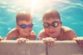 Little boys holding swimming pools edge