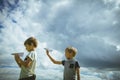 Little boys with paper planes against blue sky Royalty Free Stock Photo