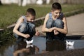 Little boys playing with paper boats in puddle Royalty Free Stock Photo