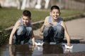 Little boys playing with paper boats in puddle Royalty Free Stock Photo