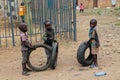 Little boys playing with the wheels on the street in Africa Royalty Free Stock Photo