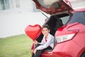 Little boys sitting on the back door of the car with balloon heart hand Royalty Free Stock Photo