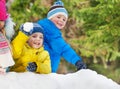 Little boys throw snowballs in the winter park