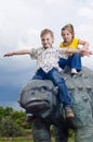 Little brave children on a dinosaur in a park