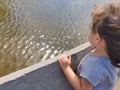 Little Brazilian girl watching the fountain waves in the wind Royalty Free Stock Photo