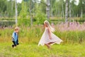 Little brother and blonde sister have fun outdoors