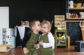 Little brother kissing his pretty sister in a creative class. Royalty Free Stock Photo