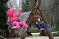 Little brother and sister laughing while having fun on a swing. Royalty Free Stock Photo