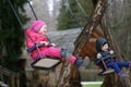 Little brother and sister laughing while having fun on a swing. Royalty Free Stock Photo