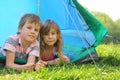 Little brother and sister lying inside tent