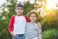 Little brother and sister standing embracing and looking at camera in park Royalty Free Stock Photo