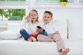 Little brother and sister watching tv on couch Royalty Free Stock Photo