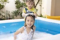 The little brother was washing his sister`s hair in an inflatable pool. girl and boy playing with soap bubbles in the swimming po Royalty Free Stock Photo