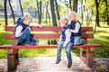 Little brothers playing chess with sister on bench in park. Children intelligence development. Family leisure time. Kids playing Royalty Free Stock Photo