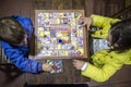 Little brothers playing Goose Game over wooden vintage table